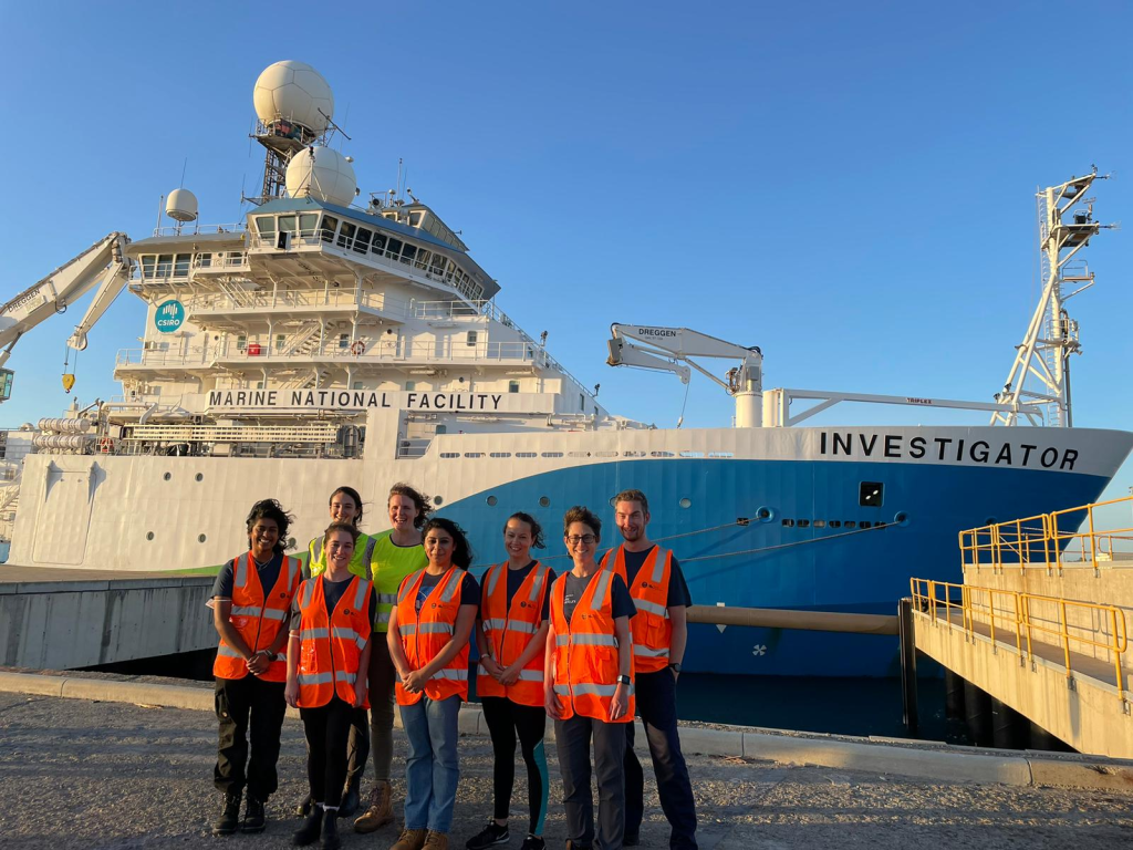 group of students and researchers in front of research vessel 